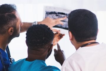 three doctors looking at an x ray